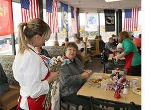 Hy-Vee employee handing out flowers to veterans